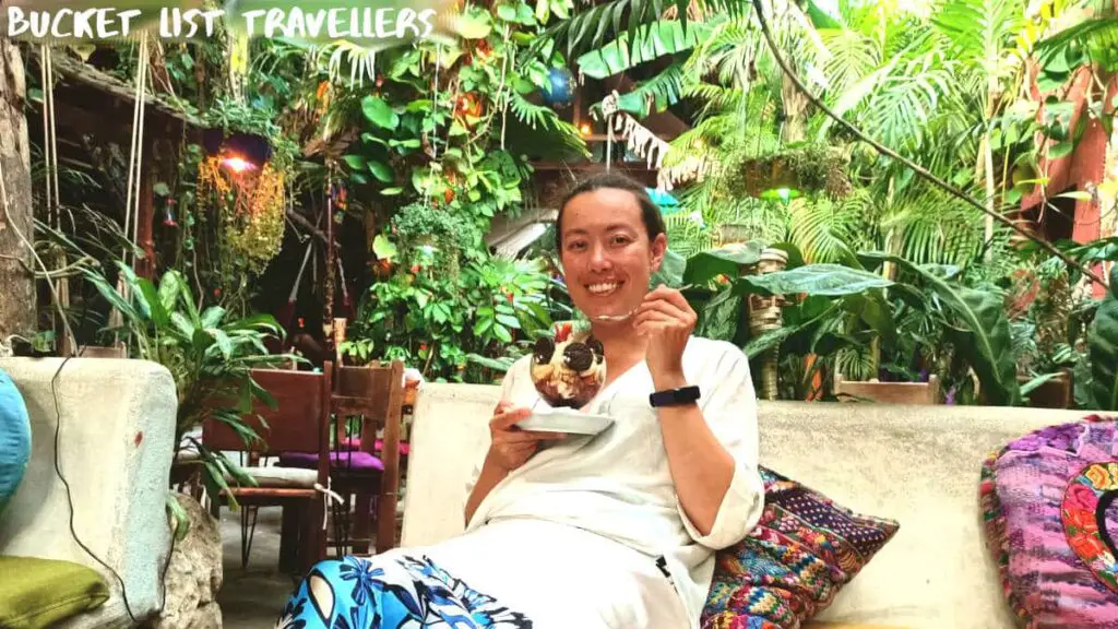 Woman eating oreo and ice cream sundae at Los Amigos Hostel Flores Guatemala