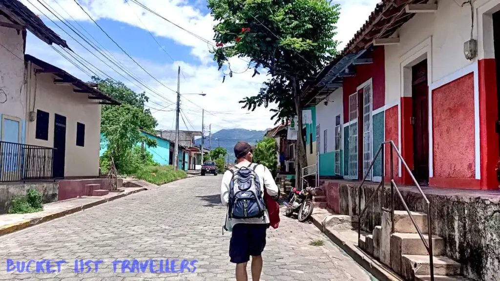 Man Walking through the streets of Granada Nicaragua, colourful buildings, volcano Mombacho in background