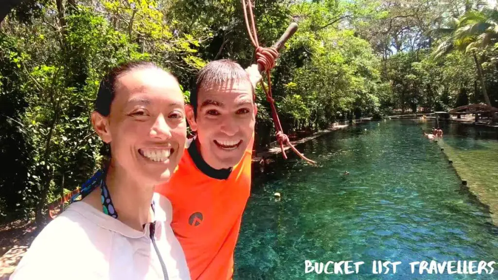 Smiling Couple at rope swing platform at Ojo de Agua Ometepe Island Nicaragua