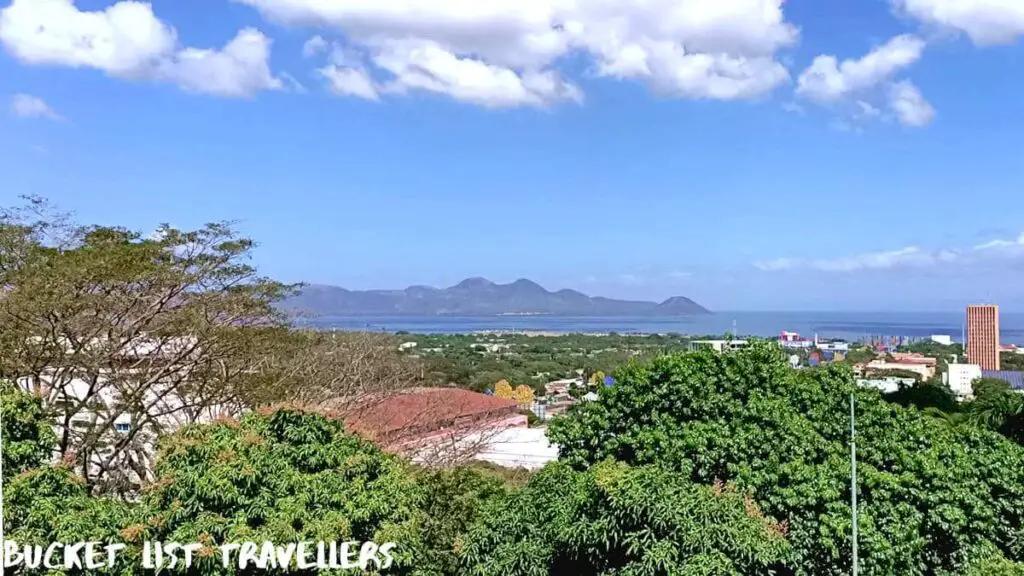 Views over the city of Managua Nicaragua from the lookout point Loma de Tiscapa. Volcanoes, hills, Lake Managua and Puerto Salvador Allende in the distance, blue sky with white clouds