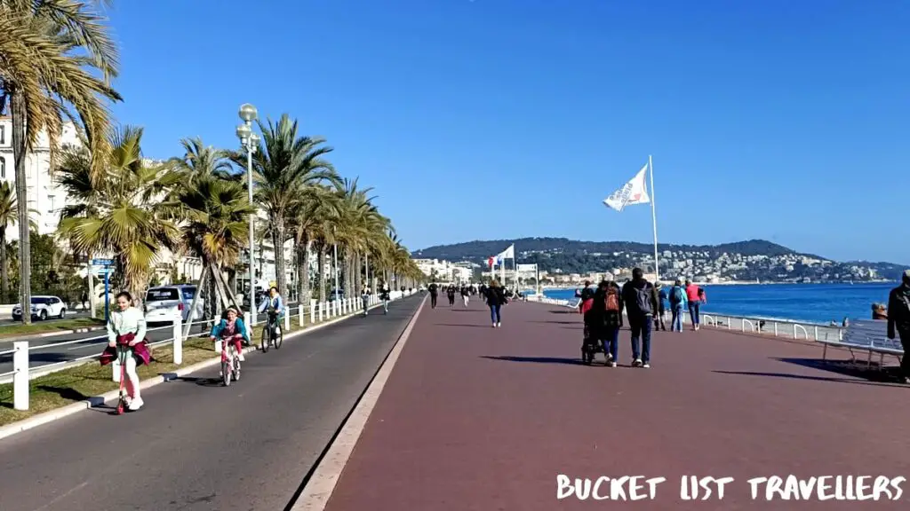 Bike Path on Promenade des Anglais Nice France, blue sky, Mediterranean Sea, people walking on promenade, girls cycling and scootering