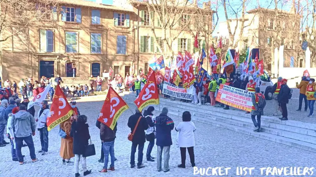 Protesters in the square outside Palais des Papes in Avignon France, Protesters carrying red flags
