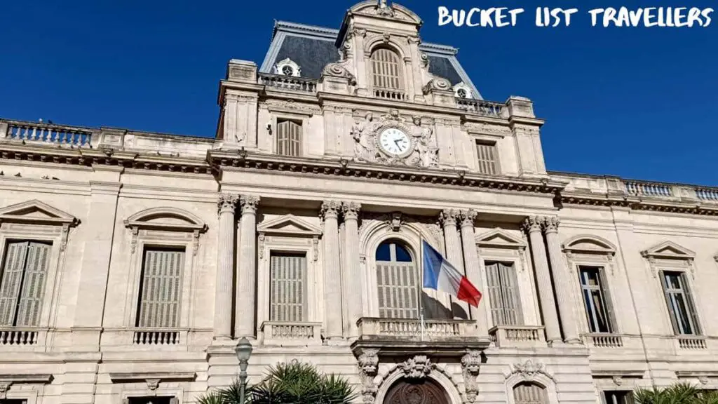 Préfecture de l'Hérault Montpellier France, sandstone building with clock and French flag