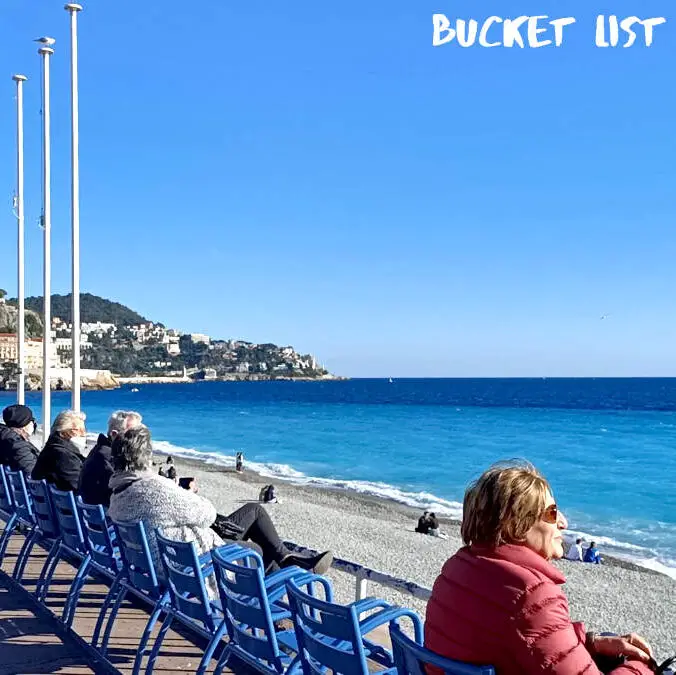 People sitting overlooking the ocean at Quai des États-Unis Nice France