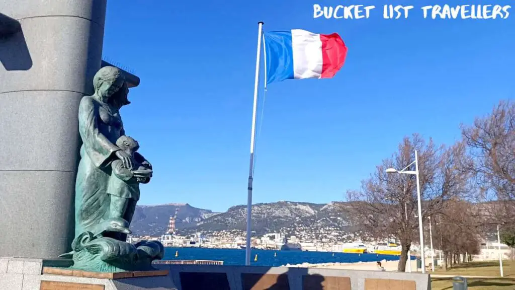 French Flag at Parc de la Tour Royale Toulon France, statue of woman and child, harbour in the background