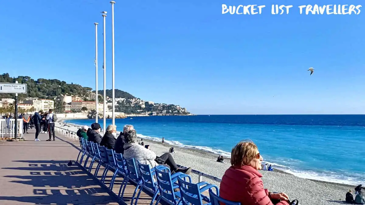 People sitting overlooking the ocean at Quai des États-Unis Nice France