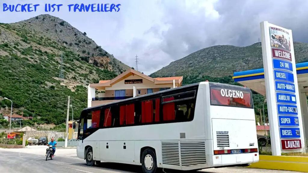 Bus from Himara to Saranda Albania, bus at gas staton with green hills surrounding the area