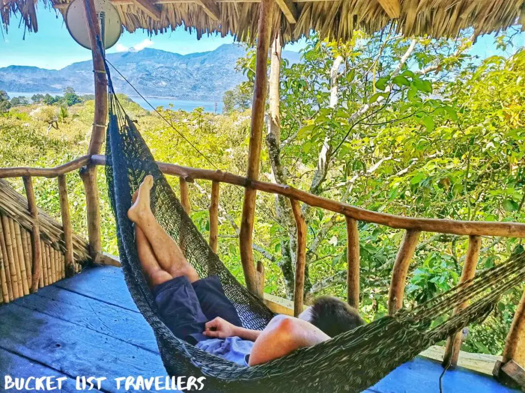 Man sitting in hammock at Hostal Azul de Lago Lake Yojoa