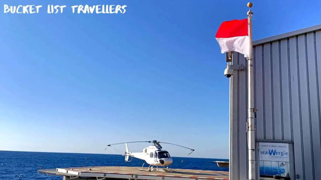 Helicopter at Monaco Heliport, Monaco Flag, red and white flag, Mediterranean Sea in background