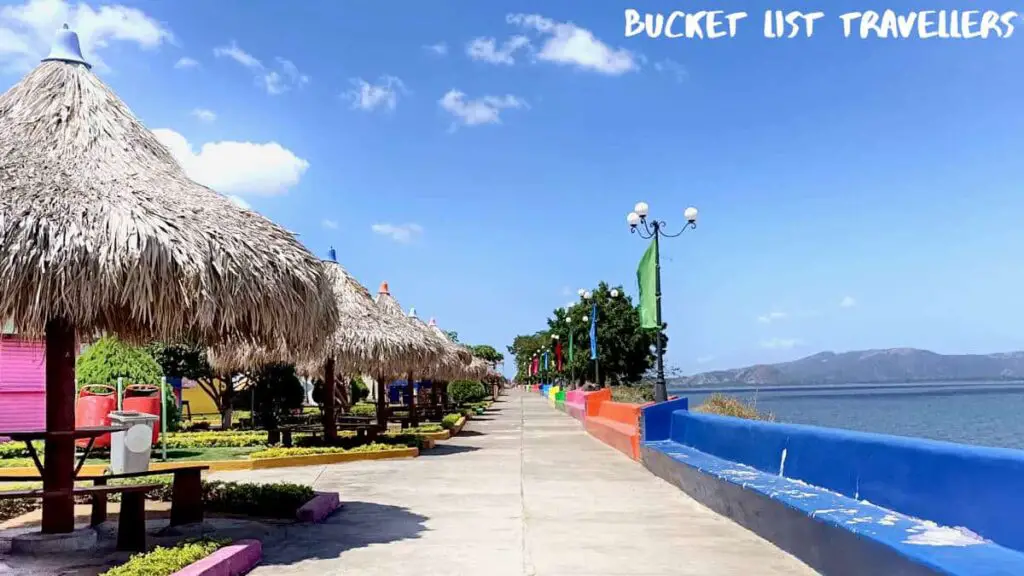 Malecon area next to Lake Managua at Puerto Salvador Allende Managua Nicaragua; straw covered cabanas with colourful flags; water views and hills in background
